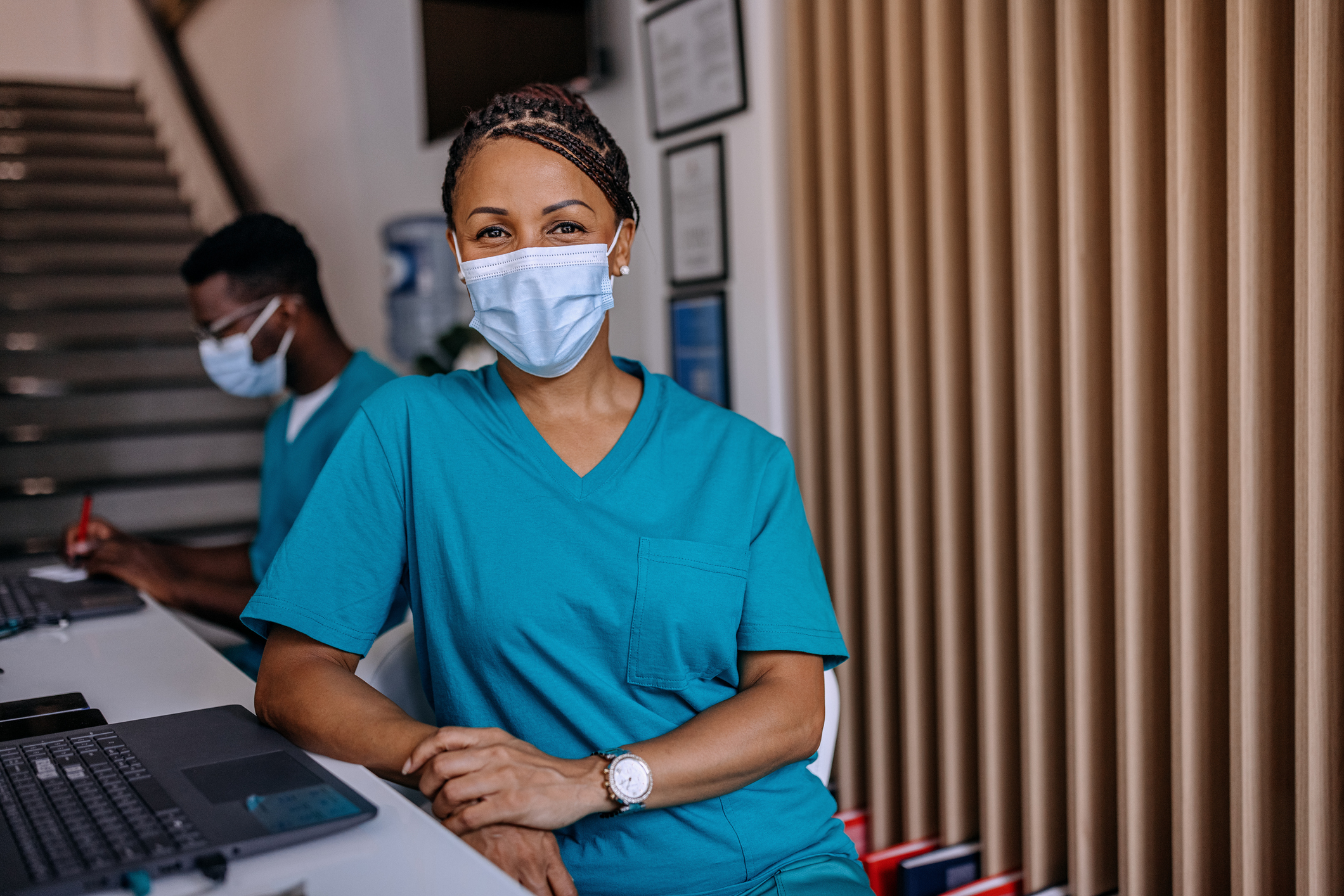 Medical assistant wearing mask at a desk