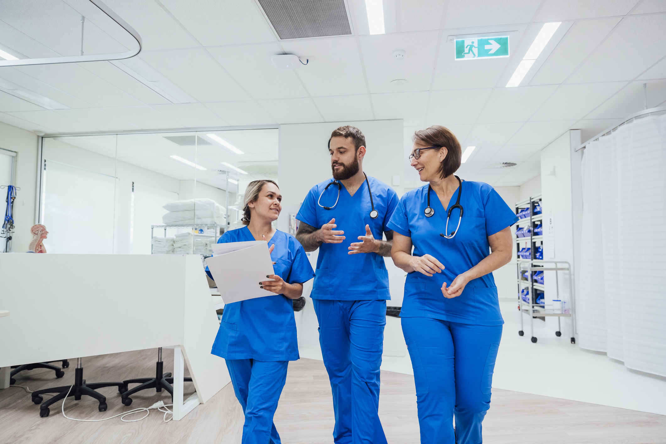 Three nurses walking and talking together in a hospital