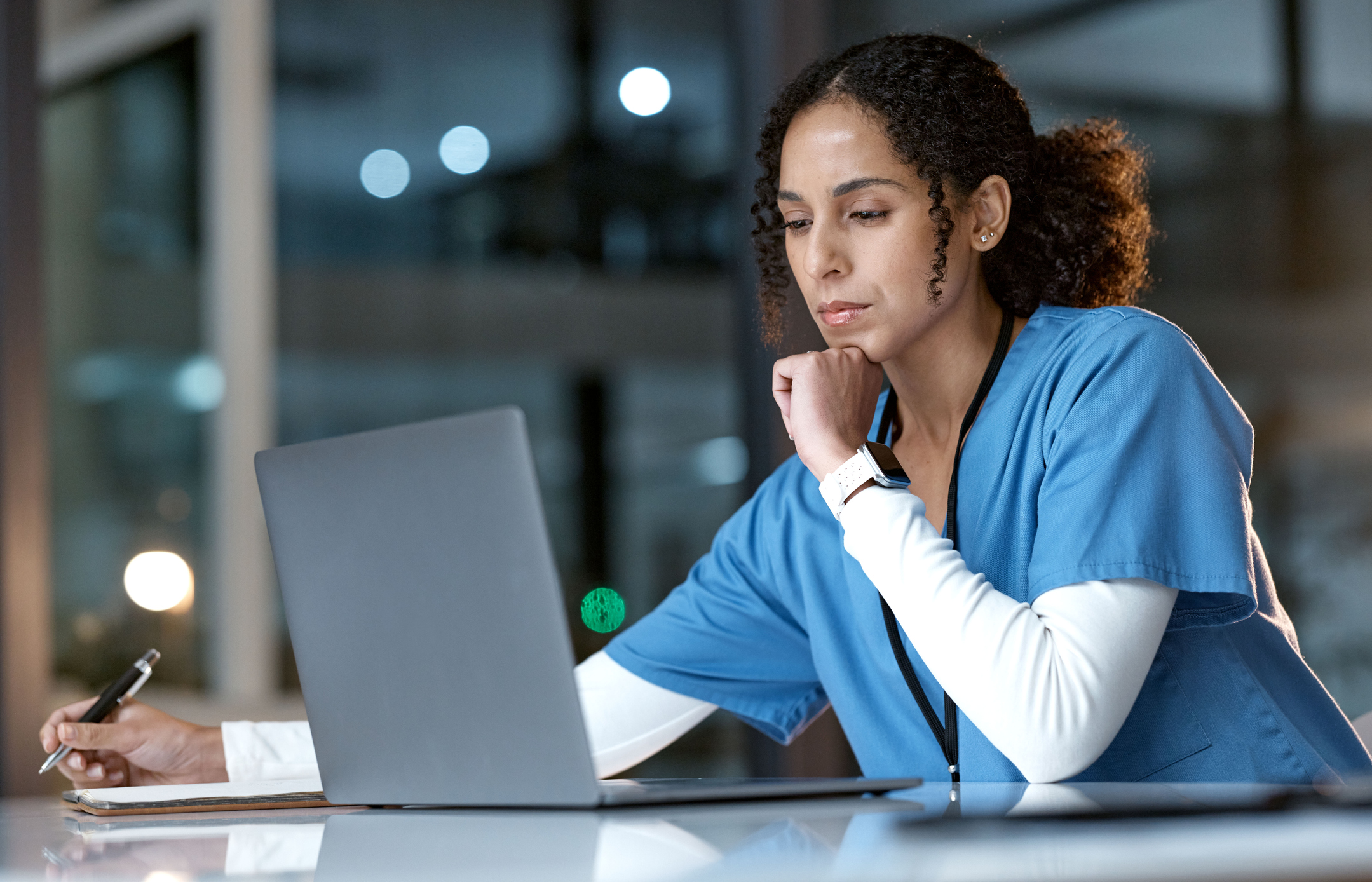 Nurse studying on laptop at night